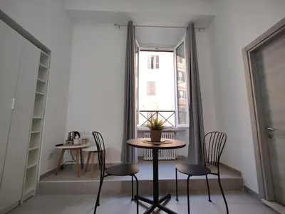 a table and chairs in a room with a window at Lifestyle 168 Guest House in Rome