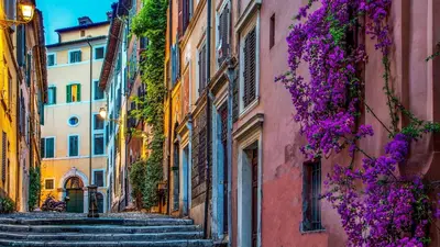 an alley with stairs in an old town with purple flowers at The Inn at the Roman Forum Autograph Collection - The Inn At The Roman Forum Holidays in Rome