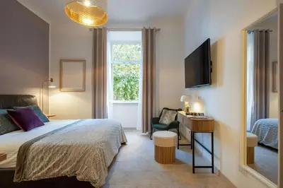 a bedroom with a bed and a desk and a television at BruSilva al Colosseo in Rome