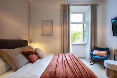 a bedroom with a bed and a chair and a window at BruSilva al Colosseo in Rome