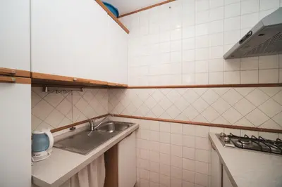 a small white tiled kitchen with a sink at Trevi Fountain by BuddyRent in Rome