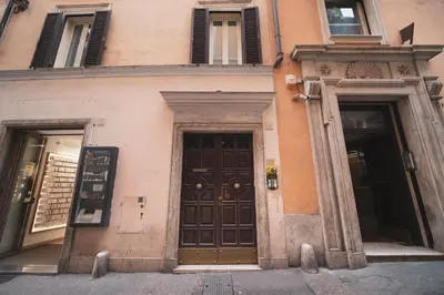 a building with two brown doors and two windows at Trevi Fountain by BuddyRent in Rome
