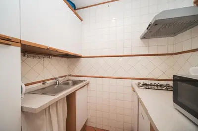 a small kitchen with a sink and a microwave at Trevi Fountain by BuddyRent in Rome