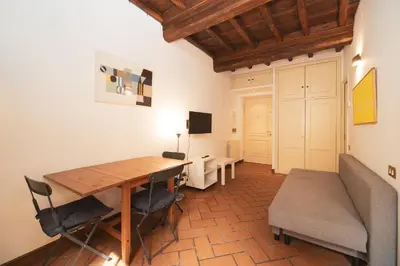 a room with a wooden table and chairs and a desk at Trevi Fountain by BuddyRent in Rome