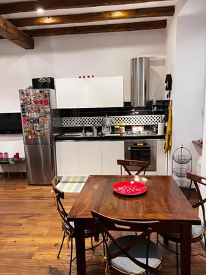 a kitchen with a wooden table and a refrigerator at Casetta del Bassotto in Rome