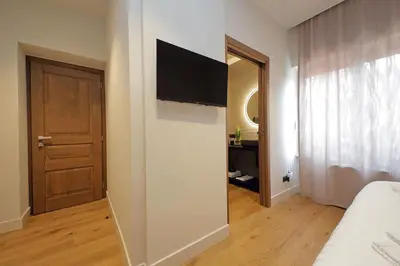 a bedroom with a television on a wall next to a door at The Place Gallia in Rome