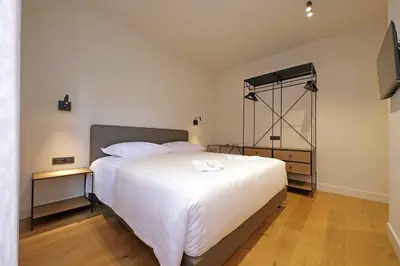 a bedroom with a large white bed and a television at The Place Gallia in Rome