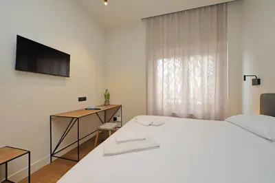 a bedroom with a white bed and a television at The Place Gallia in Rome