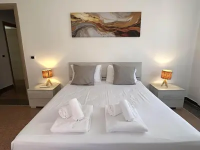 a bedroom with a white bed with two lamps at Planny Apartment - Vaticano in Rome