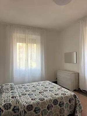 a bedroom with a bed and a dresser and a window at Planny Apartment - Vaticano in Rome