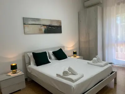 a bedroom with a large white bed with towels on it at Planny Apartment - Vaticano in Rome