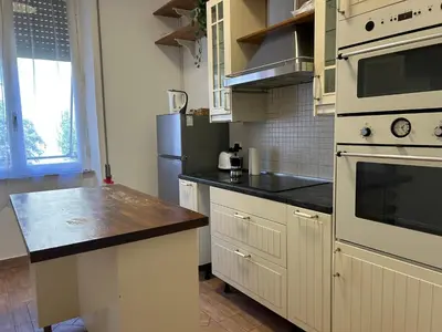 a kitchen with white cabinets and black counter tops at Planny Apartment - Vaticano in Rome