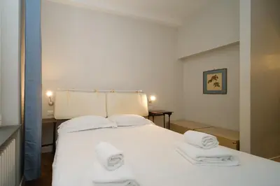 a bedroom with a white bed with towels on it at Castel Sant'Angelo by BuddyRent in Rome