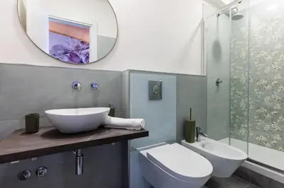 a bathroom with a sink and a toilet and a mirror at Fantastic Rome Guest House in Rome