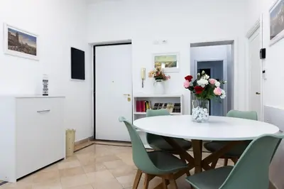 a dining room with a white table and green chairs at Fantastic Rome Guest House in Rome