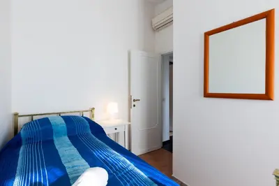 a bedroom with a blue bed and a mirror at Fantastic Rome Guest House in Rome