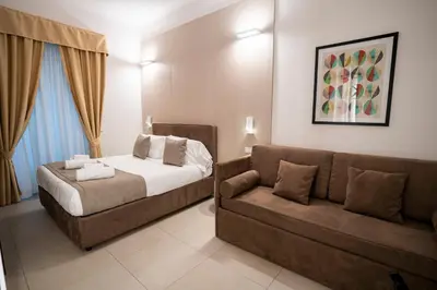 a bedroom with a bed and a couch at Cicerone's Luxury Suites in Rome