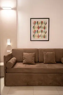 a brown couch in a living room with a painting at Cicerone's Luxury Suites in Rome