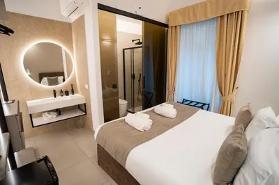 a hotel room with a large bed and a mirror at Cicerone's Luxury Suites in Rome