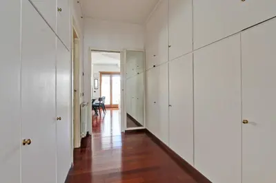 a hallway with white cabinets and a hard wood floor at Cherry in Rome in Rome