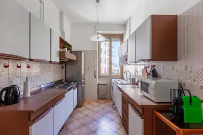 a kitchen with white cabinets and a sink and a microwave at giovanni house roma in Rome