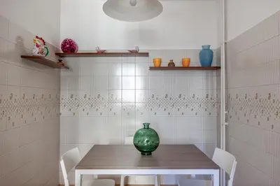 a table with a green vase sitting on top of it at giovanni house roma in Rome