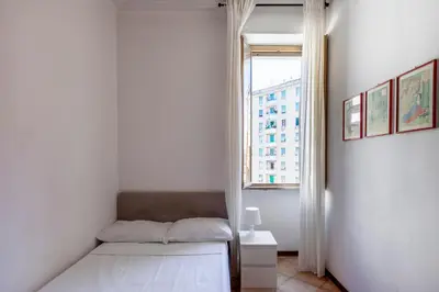 a white room with a bed and a window at giovanni house roma in Rome