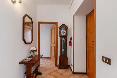 a hallway with a grandfather clock and a table at giovanni house roma in Rome