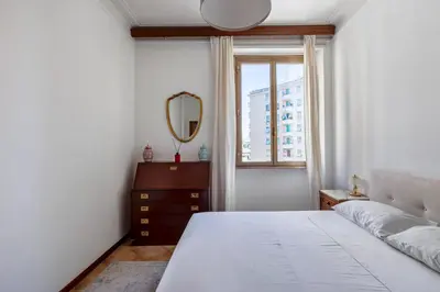 a bedroom with a bed and a mirror and a window at giovanni house roma in Rome