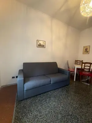 a living room with a blue couch and a table at Casa Città del Vaticano in Rome