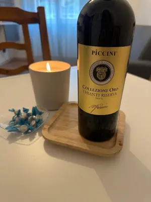a bottle of wine sitting on a table with a candle at Casa Città del Vaticano in Rome