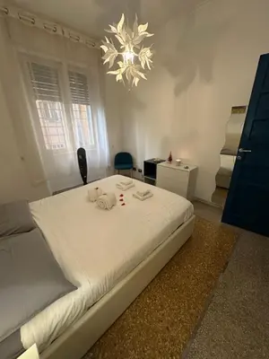 a bedroom with a large white bed with a chandelier at Casa Città del Vaticano in Rome