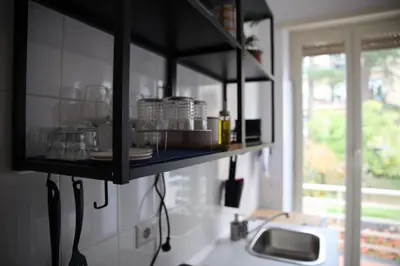 a kitchen with a shelf with dishes and a sink at Casa Fiore in Rome