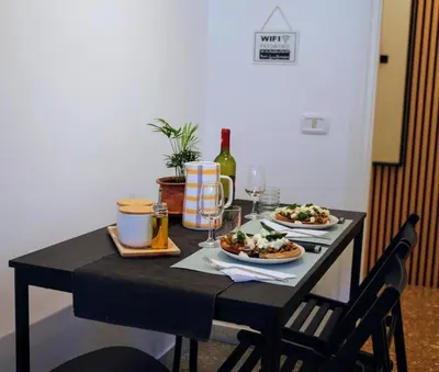 a table with two plates of food and a bottle of wine at Casa Fiore in Rome