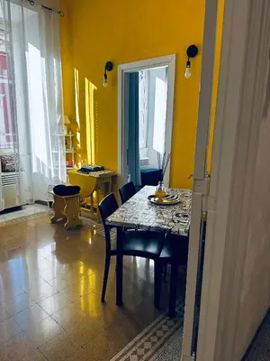 a dining room with a table and chairs and yellow walls at Home Sweet Rome Vatican in Rome