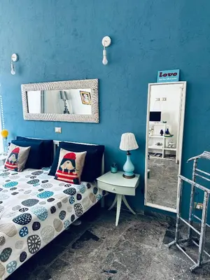 a blue bedroom with a bed and a mirror at Home Sweet Rome Vatican in Rome