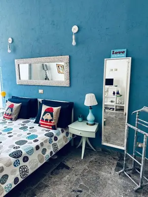 a blue bedroom with a bed and a mirror at Home Sweet Rome Vatican in Rome