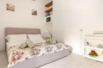 a bedroom with a bed with a floral bedspread at Daisy Home - Tiburtina loft in Rome WiFi in Rome