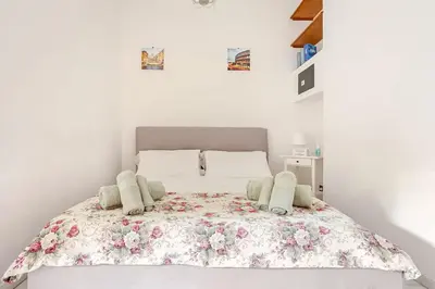 a bedroom with a bed with a floral bedspread at Daisy Home - Tiburtina loft in Rome WiFi in Rome