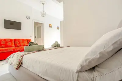 a bedroom with a large bed and a red couch at Daisy Home - Tiburtina loft in Rome WiFi in Rome