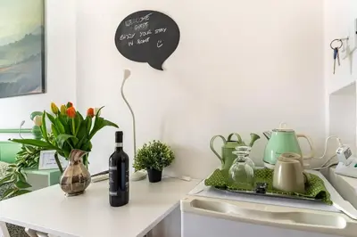 a kitchen with a counter with wine bottles and flowers at Vatican Almond Tree Penthouse in Rome