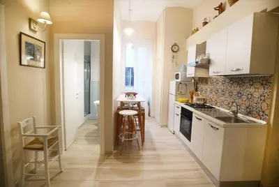 a kitchen with white cabinets and a table and chairs at Alloggio Machiavelli 59 in Rome