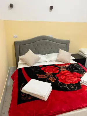 a bed with a red and black blanket and pillows at RATTAZZI ROMA CENTRo in Rome