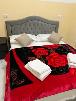 a bed with a red and black blanket and red roses at RATTAZZI ROMA CENTRo in Rome
