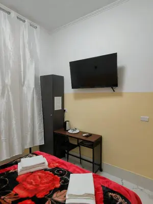 a room with a bed with a television on the wall at RATTAZZI ROMA CENTRo in Rome
