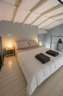 a large white bed with two towels on top of it at Stylish duplex with terrace Rome in Rome