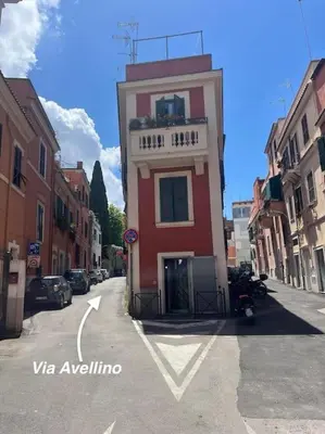 a red and white building on the side of a street at Stylish duplex with terrace Rome in Rome