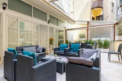 an outdoor patio with wicker furniture and blue pillows at Merulana 43 - Guest House in Rome