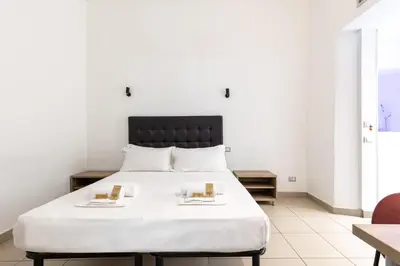 a bedroom with a white bed with two books on it at Merulana 43 - Guest House in Rome