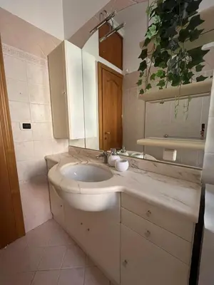a white bathroom with a sink and a mirror at ALGA Roma in Rome